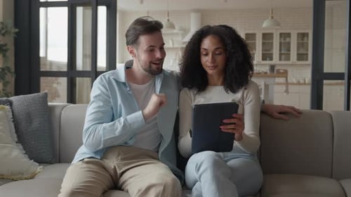 Couple Playfully Debates Purchase Man Taps Screen Woman Smiles But Disagrees