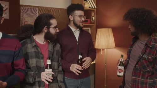 Friends Chatting and Holding Bottled Drinks Indoors