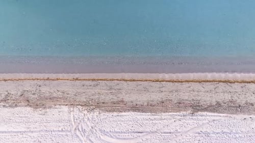 Aerial drone shot of the empty beach as the waves crash on the beach