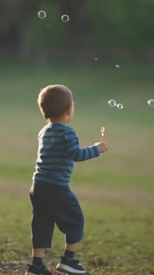 Little Boy in the Park Blowing Catching and Chasing Soap