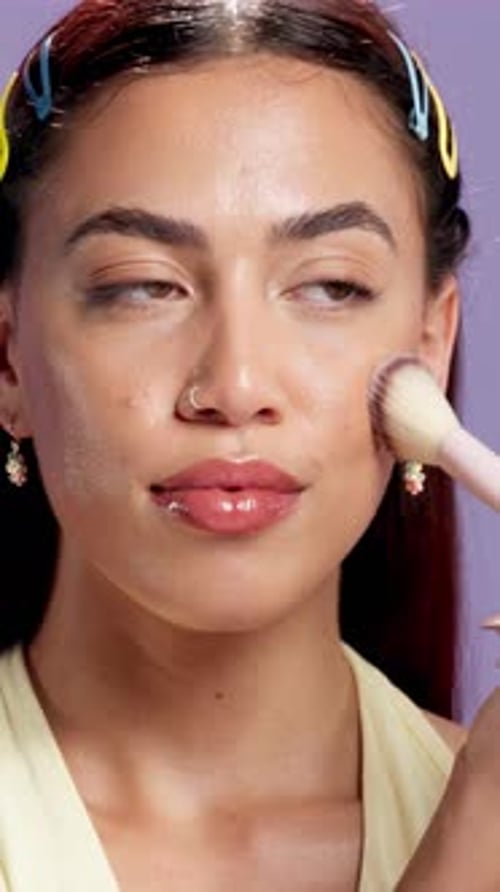 Beauty, makeup brush and smile with face of woman in studio for shine, foundation application