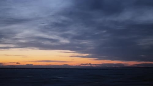 Soleil couchant au-dessus du lac gelé avec des oiseaux volant au loin