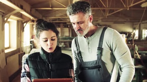 Man and Woman Workers with Tablet in the Carpentry Workshop