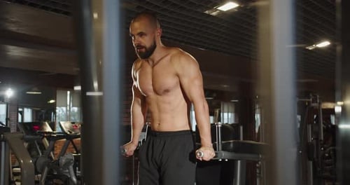 Ein Profisportler fährt im Fitnessstudio an den Barren hoch