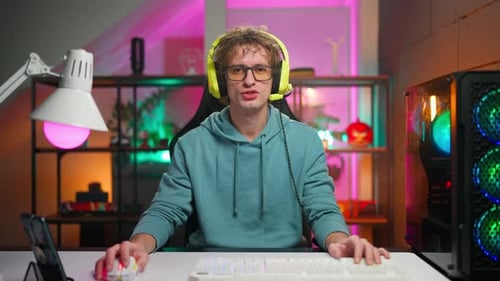 Young Adult Using Computer with Colorful Lighting