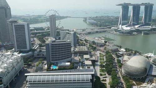 Aerial time-lapse of traffic moving through the streets of downtown Singapore. Slow pullout.