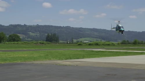 Hubschrauber, der am ländlichen Flughafen seitwärts fliegen. mit Red Epic