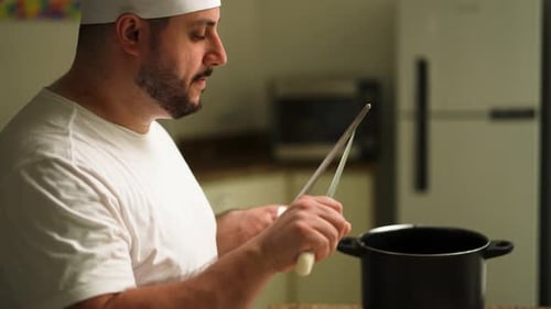 Man Sharpens Knife in Kitchen