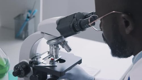 Scientist Using Microscope in Bright Modern Laboratory