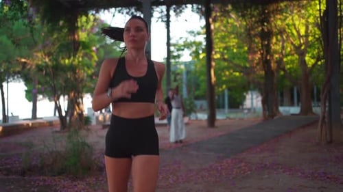 Young Sportswoman in Activewear Jogging in Park