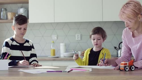 Children Drawing Together at Kitchen Table with Adult