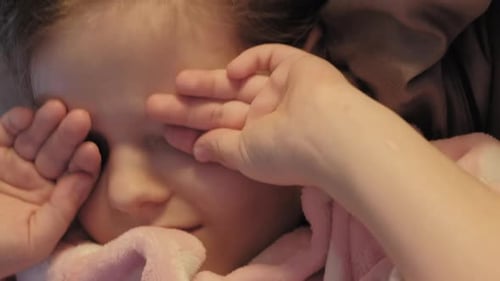 Child Waking Up in Bed Rubbing Eyes