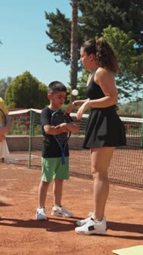 Instructor And Children Play Tennis On The Court