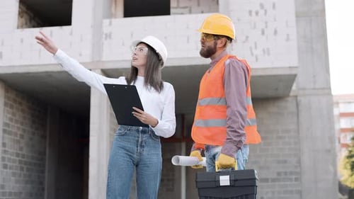 Bauarbeiter besprechen bei Tageslicht Projektdetails auf der städtischen Baustelle