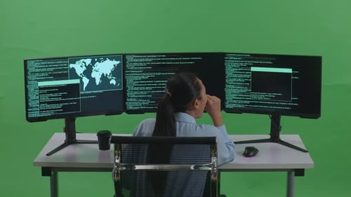 Back View Of Tired Asian Woman Yawning While Write Code With Multiple Screens In Green Screen