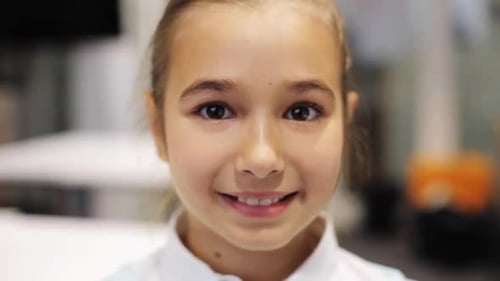 Smiling girl looks at the camera indoors
