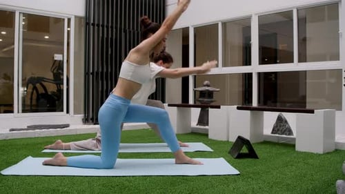 Women Doing Yoga on Mats Inside Indoor Gym