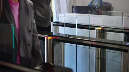 Passing Through a Turnstile Into an Office Building Office Workers Enter and Exit Through a Modern