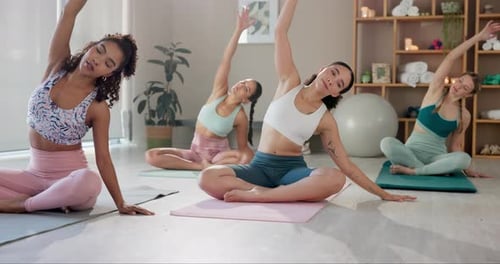 Women in yoga class stretching and exercising
