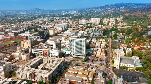 Sunny view of dense urban landscape with lively traffic on the roads. Panorama of Los Angeles hills
