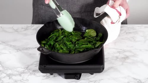 Faire sauter les épinards pour la frittata aux épinards et au jambon