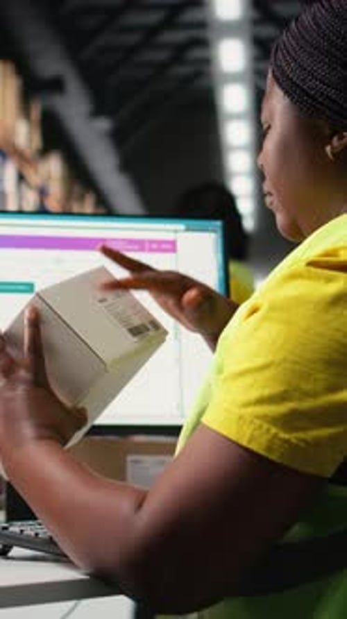 Vertical Video Black Woman Placing Adhesive Shipment Tags on Cardboard Boxes