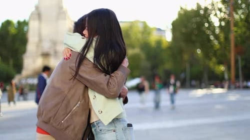 Joyful Young Couple Hugging and Kissing in a City Square