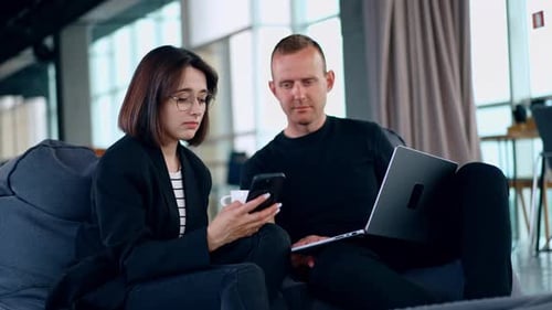 Tech Professionals Collaborating on a Laptop in Office