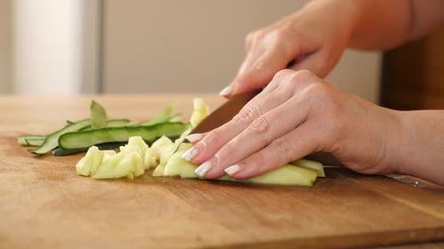 09Cucumber is cut into pieces with a knife. Cooking dishes from vegetables.