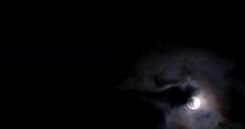 Ein heller Vollmond an einem dunklen Himmel zwischen Wolken