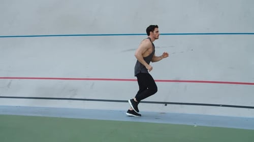 Muscular man running on track for fitness