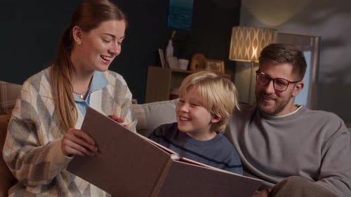 Happy Family Looking at Photo Album Together at Home