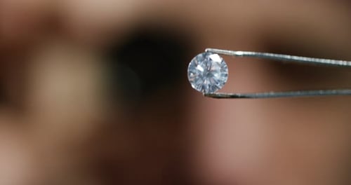 Sparkling Diamond Held in Tweezers Close Up