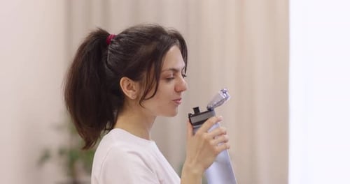 Woman Drinks Water from Bottle Close Up