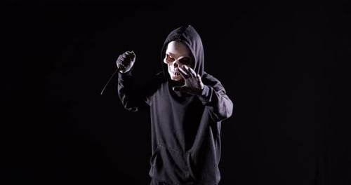 Scary Figure with Knife on Black Background
