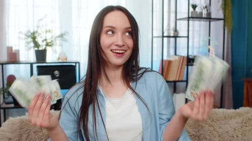 Happy Woman on Couch Holding Cash