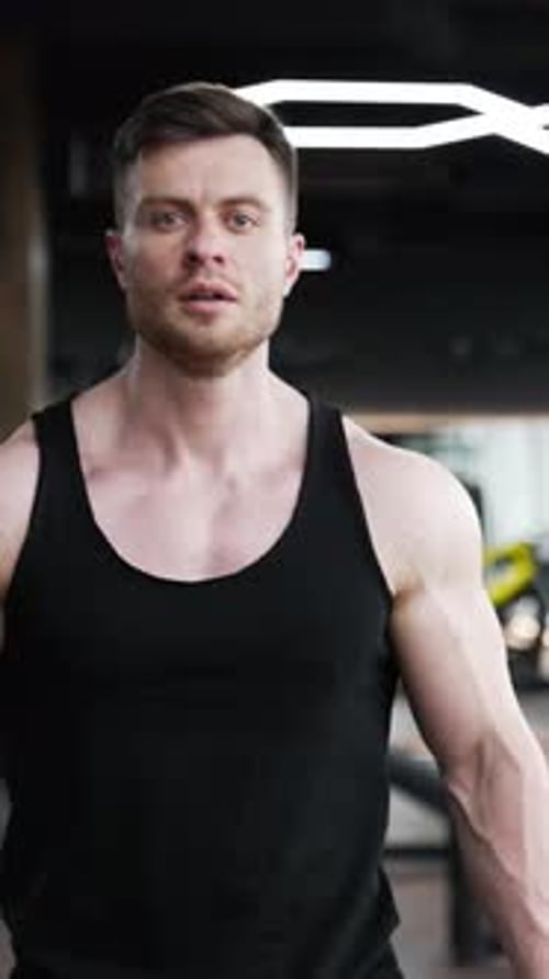 Belo atleta caminha no centro de fitness.