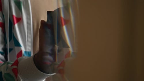 Close up of a man's hands holding a camera with a large lens, preparing to shoot