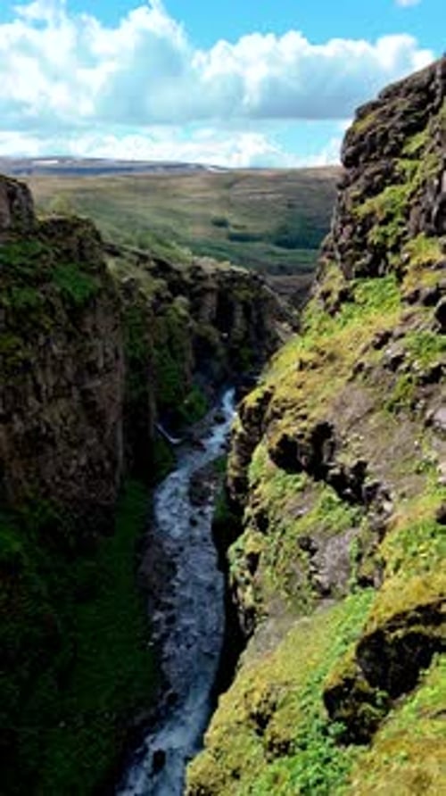 Exploring the Stunning Gray Cliffs and Flowing River Nestled in Glymur Waterfall Canyon in Iceland