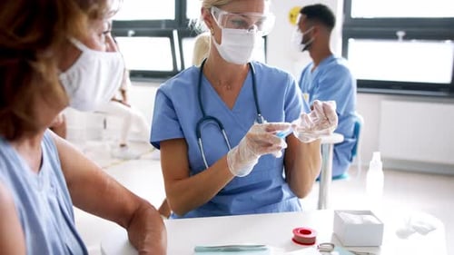 African american woman gets covid 19 vaccine at a clinic with healthcare team