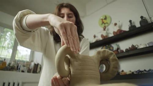 Woman Shaping Clay Sculpture in Pottery Studio