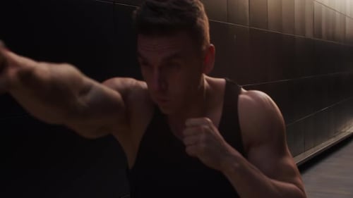 Muscular Man Boxing Outdoors at Sunrise