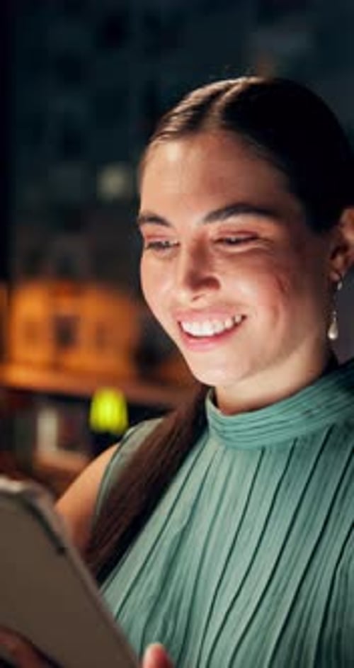 Smiling Woman Using Tablet Device at Night
