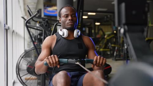 Rowing with Power Man Training Rowing Machine in Gym