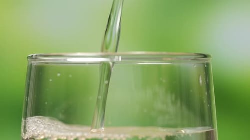 Close Up Of Drinking Water Being Poured Into A Glass On Bur Nature Screen Background