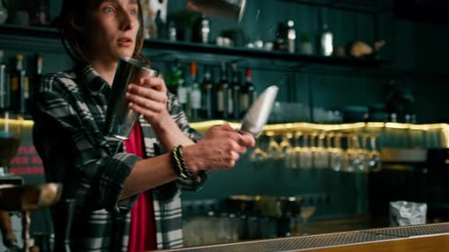 A professional bartender juggles a shaker The process of making cocktails in a club at a bar