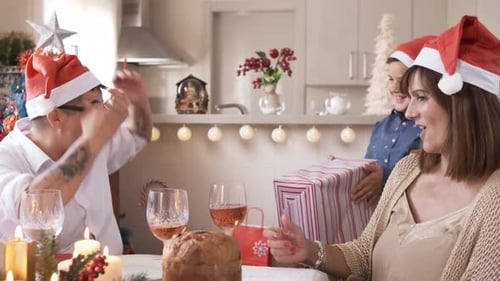 Family Celebrating Christmas with Gifts at Home