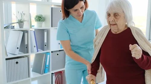 Caregiver Helping Elderly Woman to Walk