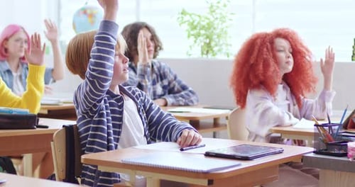 Students Raising Hands in Bright Classroom