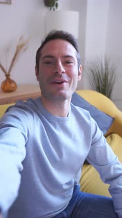 Smiling Young Adult Waving During Video Call